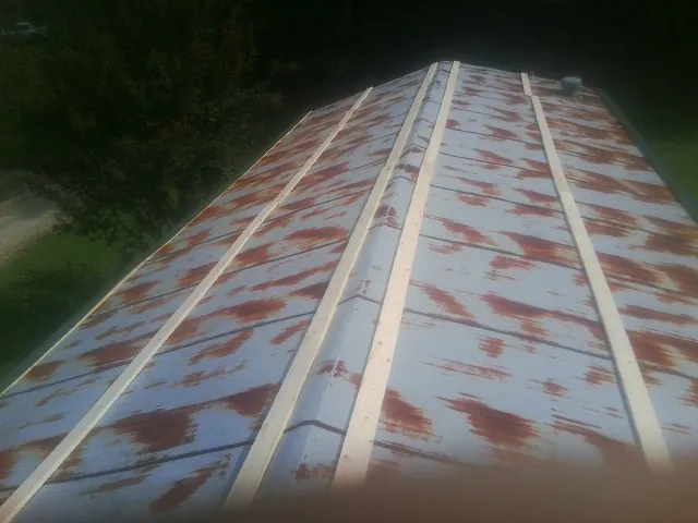 Rusted metal roof panels with new wood purlins before replacement — Storm Damage Roof Repair in Orange Beach by Roofing Brothers