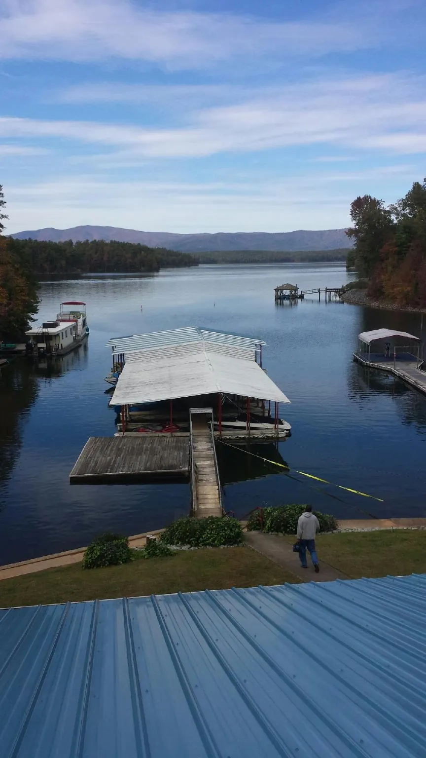 View across a lake from a newly installed blue metal roof in Orange Beach