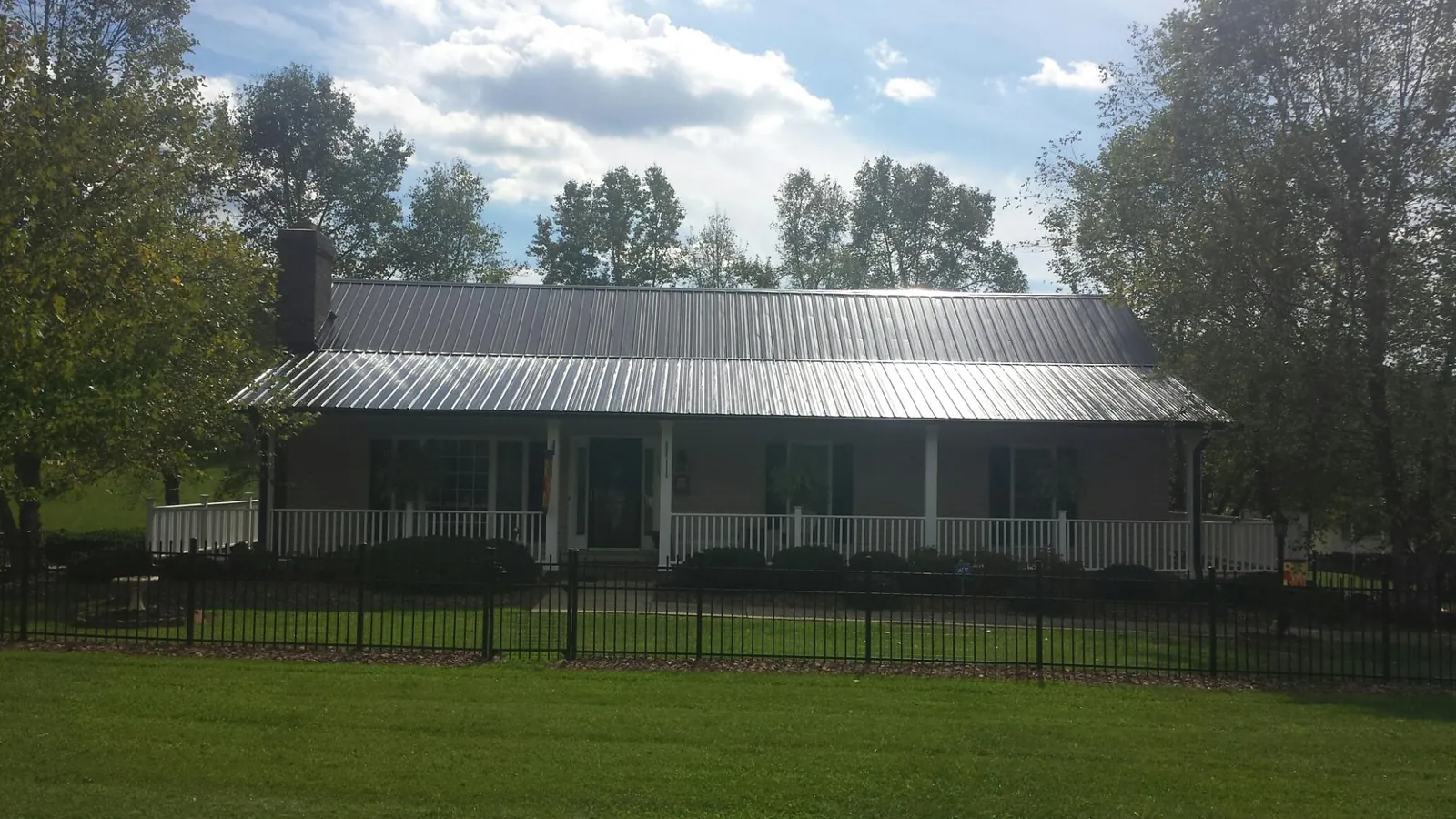 Gray metal roof on a brick ranch with a full width front porch — Gutter Guard Installation work by our crew in Orange Beach