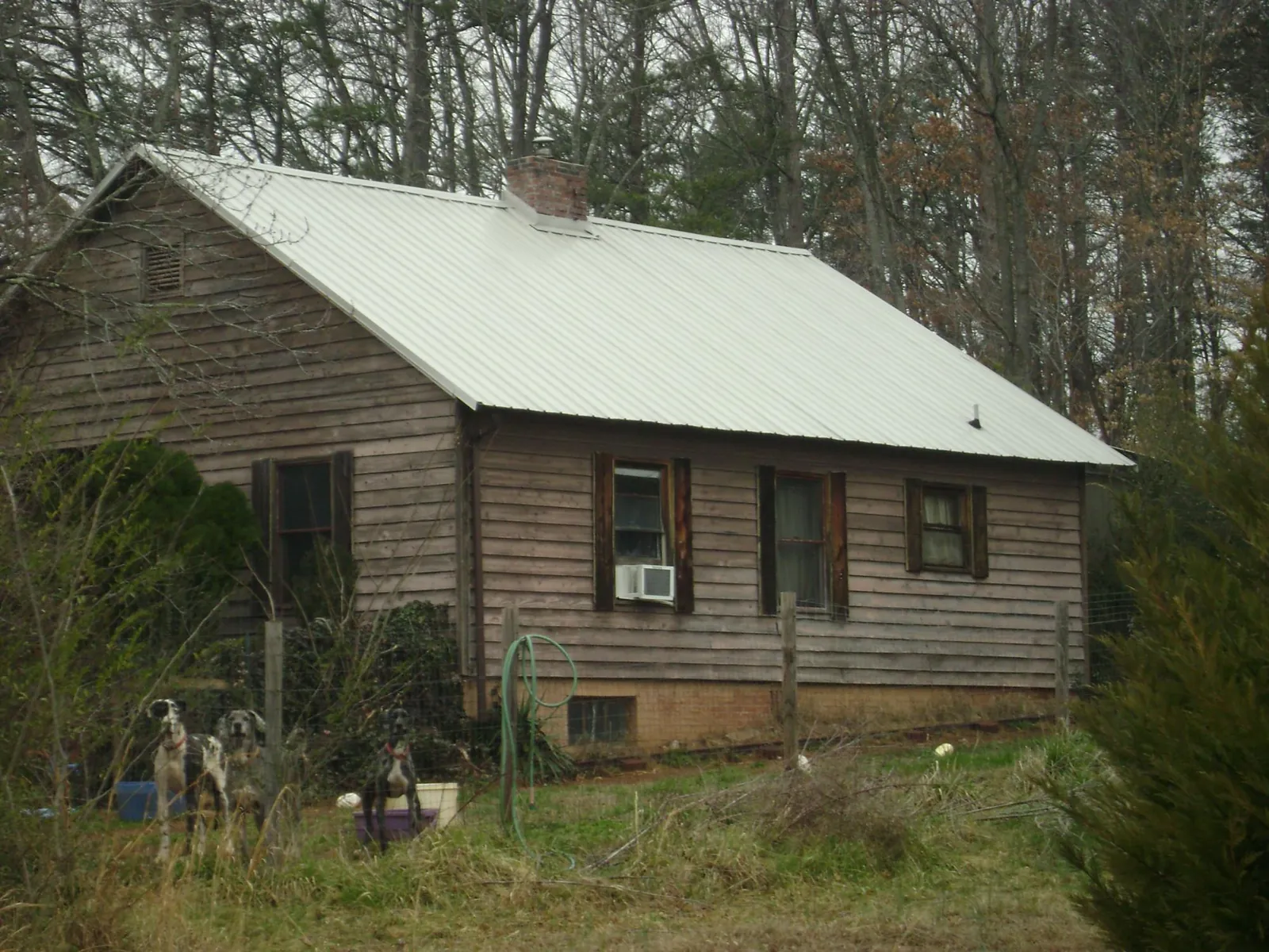 White metal roof on an old wood sided farmhouse, from a Metal Roof Installation job in Orange Beach